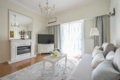 a living room with a white couch and a tv at Brand New Luxury Apt Below Acropolis in Athens