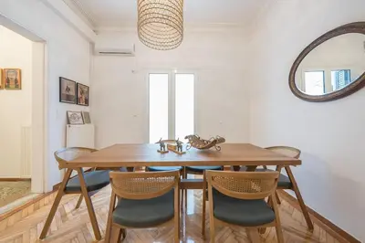 a dining room with a wooden table and chairs at Zen Melody, Neapoli in Athens