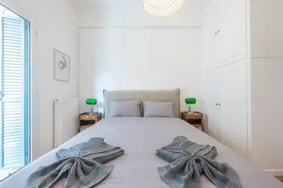 a bedroom with a large bed with towels on it at Zen Melody, Neapoli in Athens