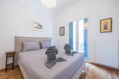 a bedroom with a large white bed with two candles on it at Zen Melody, Neapoli in Athens