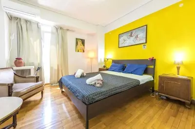 a bedroom with a bed and a yellow wall at Home away from home in Athens