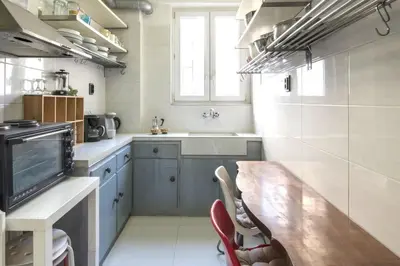 a kitchen with a wooden table and a large window at Home away from home in Athens