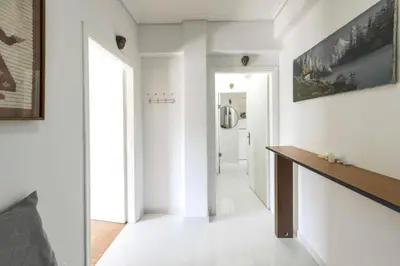 a hallway with white walls and a large painting on the wall at Home away from home in Athens