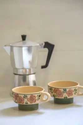 two coffee cups sitting next to a juicer at Home away from home in Athens
