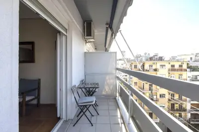 a balcony with a chair and a view of a city at Home away from home in Athens