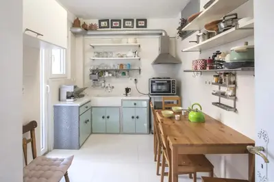 a kitchen with a wooden table in a room at Home away from Home in Athens
