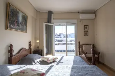 a bedroom with a bed and a door to a balcony at Home away from Home in Athens