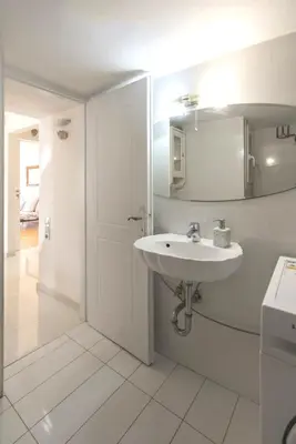 a white bathroom with a sink and a door at Home away from Home in Athens