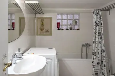 a bathroom with a sink and a tub and a mirror at Home away from Home in Athens