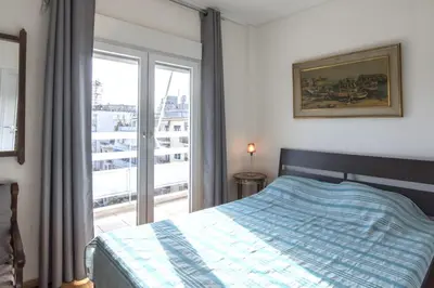 a bedroom with a bed and a large window at Home away from Home in Athens