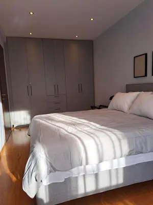 a bedroom with a large white bed and cabinets at TrilogyCentral in Athens