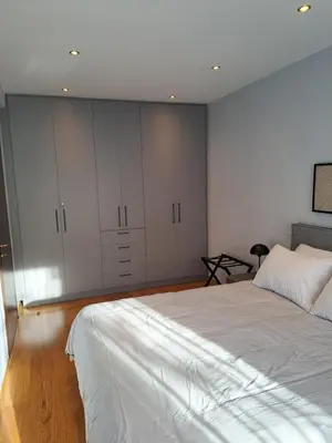 a bedroom with a large bed and white cabinets at TrilogyCentral in Athens
