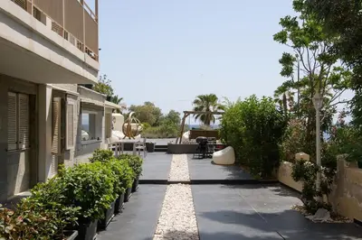 a garden path with plants and a building at Zeus1 beach front appatment, 1BR sea view in Athens