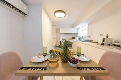 a kitchen with a wooden table with fruit and wine glasses at Zeus1 beach front appatment, 1BR sea view in Athens