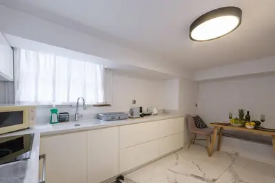 a kitchen with white cabinets and a microwave at Zeus1 beach front appatment, 1BR sea view in Athens