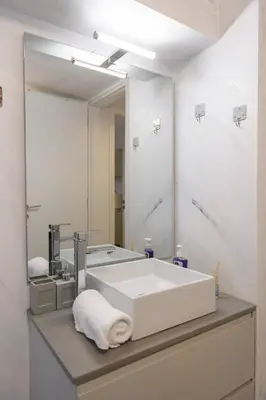 a bathroom with a large white sink and a mirror at Zeus1 beach front appatment, 1BR sea view in Athens