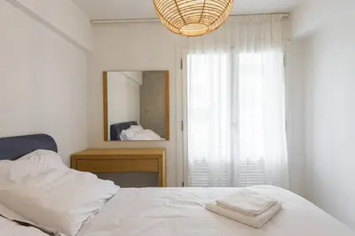 a bedroom with a white bed and a mirror at Zeus1 beach front appatment, 1BR sea view in Athens
