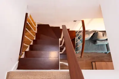 a staircase leading up to a room with a bed at Zeus2 Beach Front Apartment, 3BR in Athens