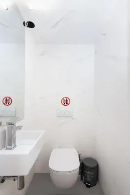 a white bathroom with a toilet and a sink at Zeus2 Beach Front Apartment, 3BR in Athens