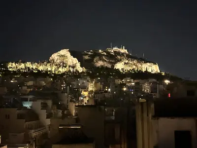 a view of a city at night with a mountain at The Best View !!! in Athens
