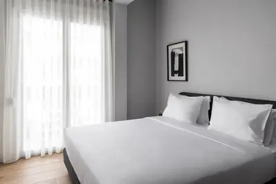 a white bed with white pillows in a bedroom at Elliot Petralona, Athens in Athens