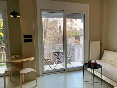 a living room with a bed and a sliding glass door at Stairway to Lycabettus in Athens