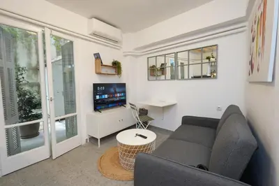 a living room with a couch and a tv at The Extravagant studio in Pagkrati, Near Stadium in Athens