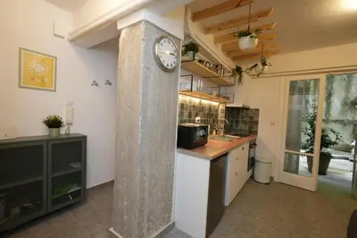 a kitchen with a column with a clock on the wall at The Extravagant studio in Pagkrati, Near Stadium in Athens