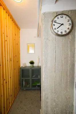 a clock on the wall of a hallway at The Extravagant studio in Pagkrati, Near Stadium in Athens