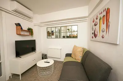 a living room with a couch and a tv at The Extravagant studio in Pagkrati, Near Stadium in Athens
