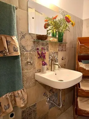 a bathroom with a sink and a mirror and flowers at Apartment Ioanneta - Vintage decorated, city center, close to metro station in Athens