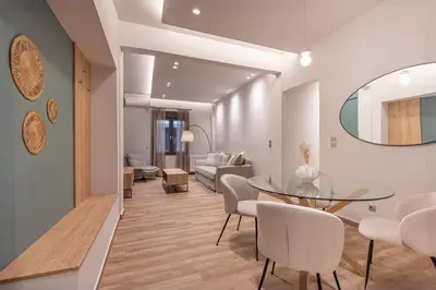 a living room with a glass table and white chairs at Phaedrus Living Pagkrati Modern Grove in Athens