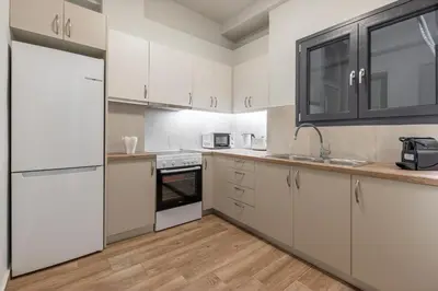 a kitchen with white appliances and wooden floors at Phaedrus Living Pagkrati Modern Grove in Athens