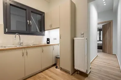 a kitchen with white cabinets and a sink and a radiator at Phaedrus Living Pagkrati Modern Grove in Athens