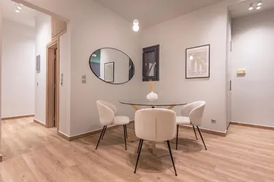 a dining room with a table and chairs and a mirror at Phaedrus Living Pagkrati Modern Grove in Athens