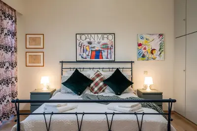 a bedroom with a bed with two lamps on the sides at Didotου Apartments in Athens