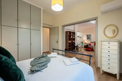 a bedroom with a bed and a mirror at Didotου Apartments in Athens
