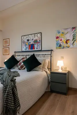 a bedroom with a bed with a lamp and a painting at Didotου Apartments in Athens