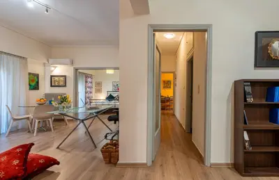 a dining room and living room with a glass table at Didotου Apartments in Athens