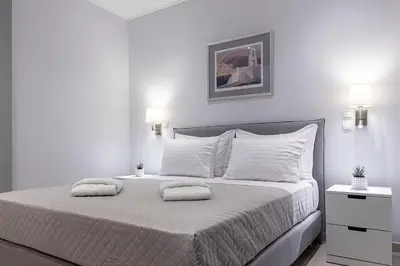 a white bedroom with a large bed with two pillows at Athens Central-Opulent and Luxurious Suites-Balcony & Views Acropolis Hills in Athens