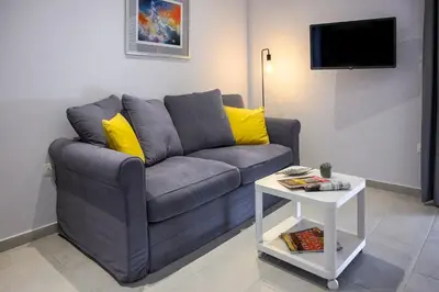 a living room with a gray couch and a white table at Athens Central-Opulent and Luxurious Suites-Balcony & Views Acropolis Hills in Athens