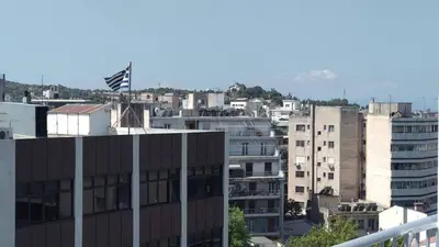 a city with a flag on top of a building at Athens Central-Opulent and Luxurious Suites-Balcony & Views Acropolis Hills in Athens