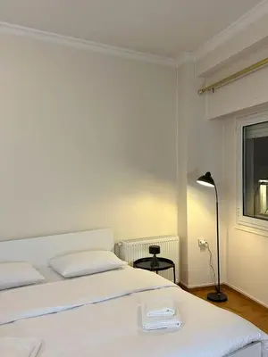 a bedroom with two beds and a lamp and a window at Acropolis Elegant Apartment II in Athens