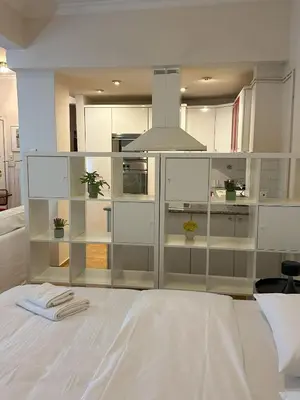 a large white kitchen with glass shelving at Acropolis Elegant Apartment II in Athens