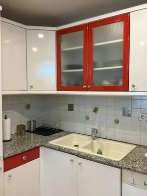a kitchen with a sink and red cabinets at Acropolis Elegant Apartment II in Athens