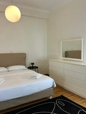 a bedroom with a bed and a dresser with a mirror at Acropolis Elegant Apartment II in Athens