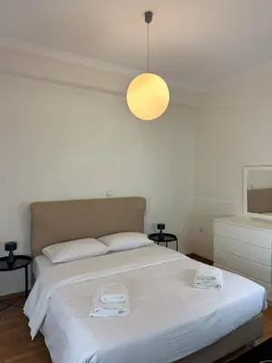 a bedroom with a large white bed with two towels on it at Acropolis Elegant Apartment II in Athens