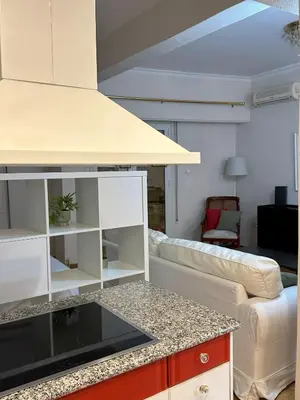 a living room with a couch and a kitchen at Acropolis Elegant Apartment II in Athens