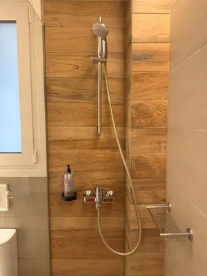 a shower with a shower head in a bathroom at Urban Muse Apartments - Archaeological Museum of Athens in Athens
