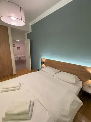 a bedroom with a large bed with white sheets and pillows at Urban Muse Apartments - Archaeological Museum of Athens in Athens